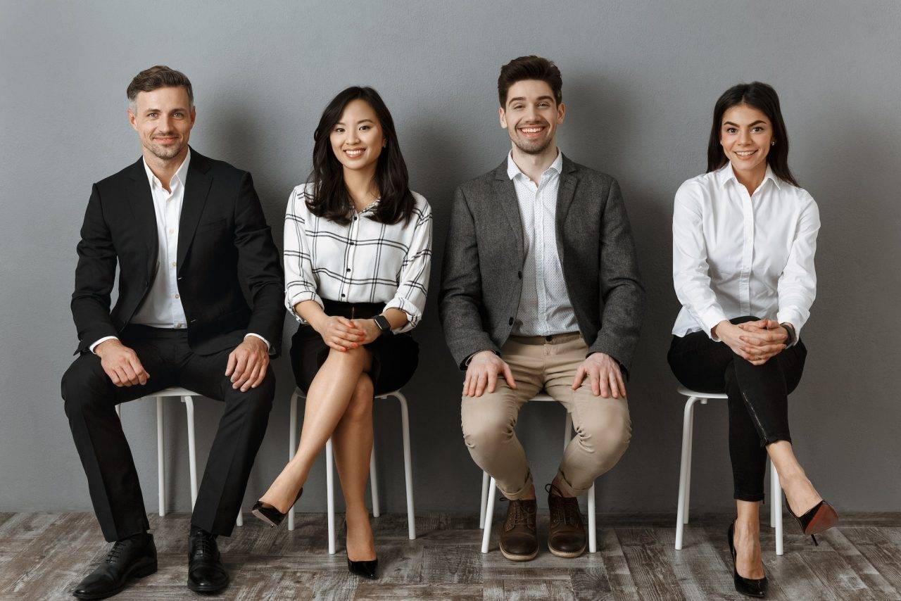 smiling-interracial-business-people-in-formal-wear-looking-at-camera-while-waiting-for-job-interview.jpg